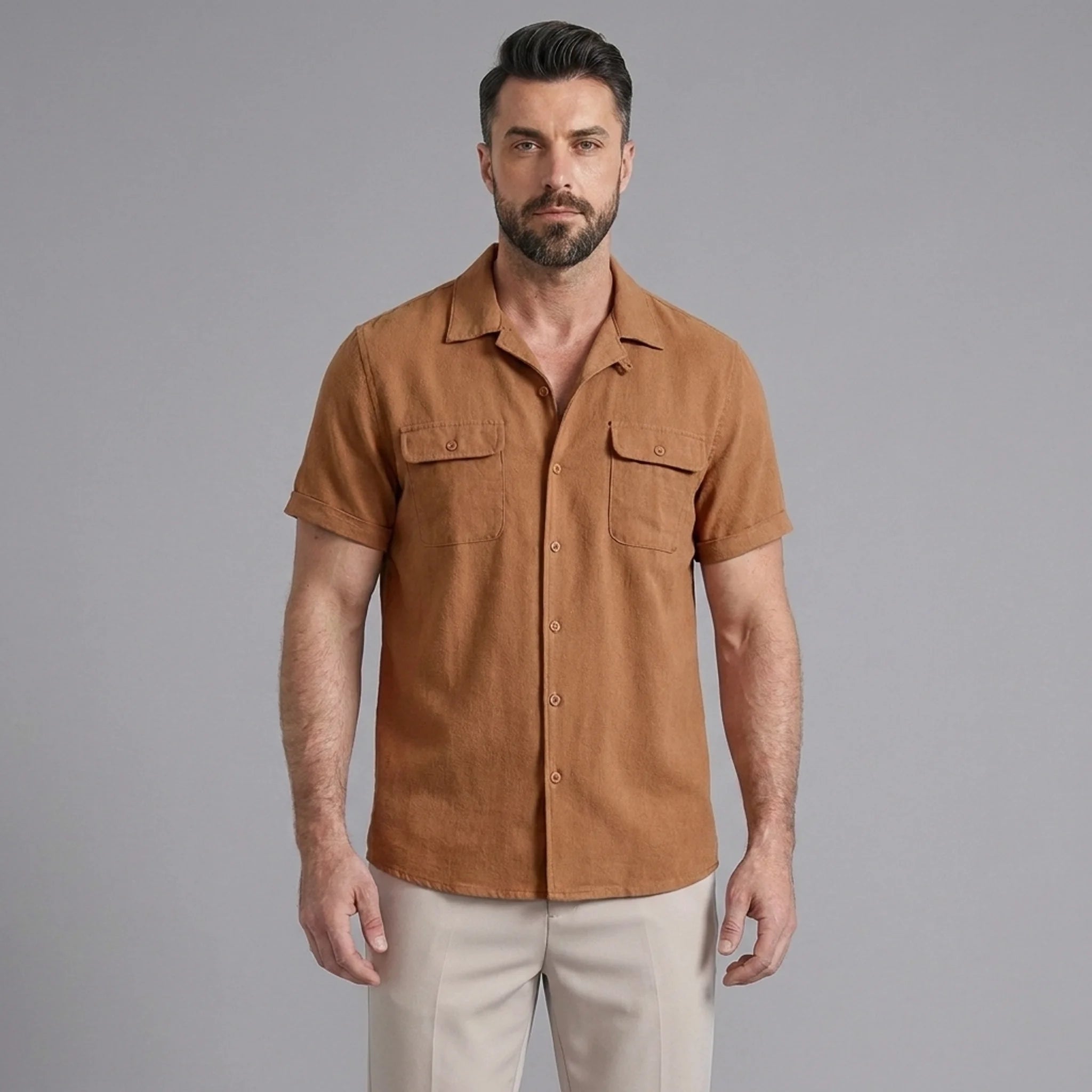 Three quarter view of man in orange linen Cuban collar shirt and slim fit tapered trousers