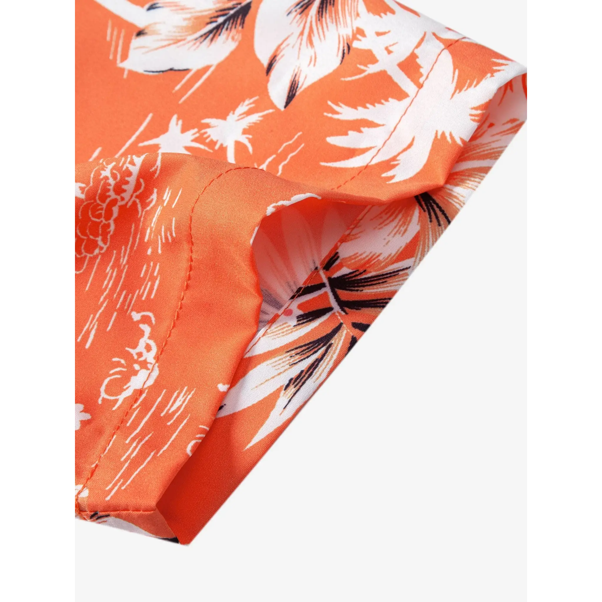 Man wearing orange palm tree tropical print shirt and swim shorts in beach lifestyle setting