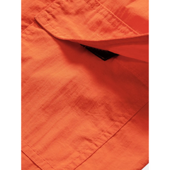 Three quarter view of man in orange palm tree tropical print shirt and swim shorts on plain background