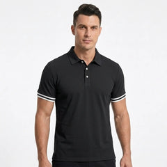 Man wearing MannerCo black polo shirt with white stripe cuffs, classic collar, short sleeves, front view