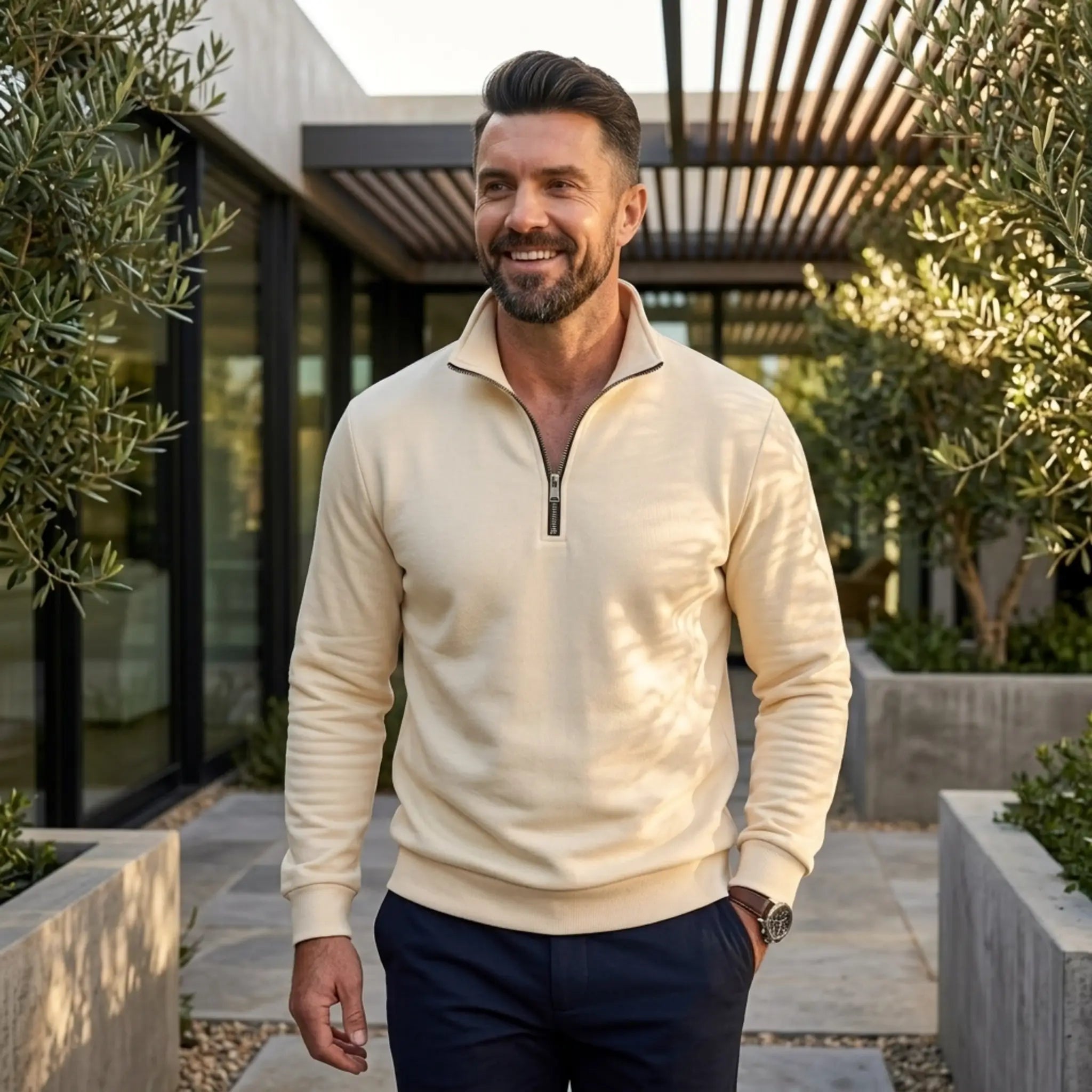 Man wearing MannerCo beige quarter zip mock neck sweater in outdoor lifestyle setting