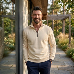 Man wearing MannerCo beige quarter zip mock neck sweater in outdoor lifestyle setting