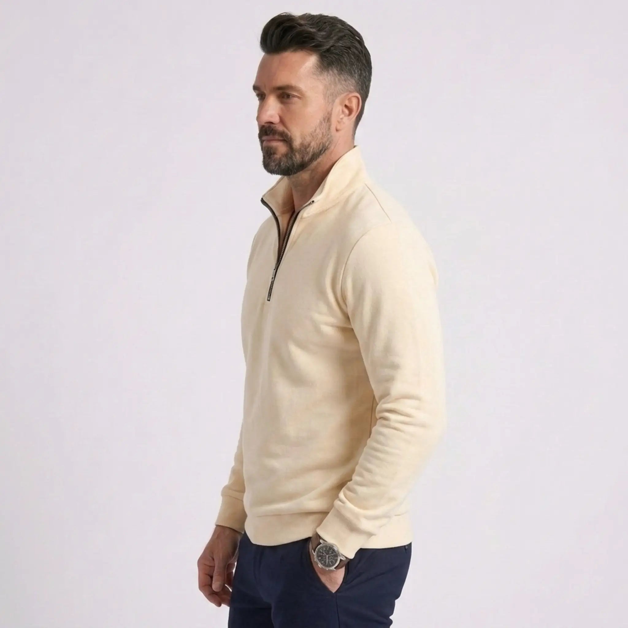 Man wearing MannerCo beige quarter zip mock neck sweater slim fit, side view on plain background