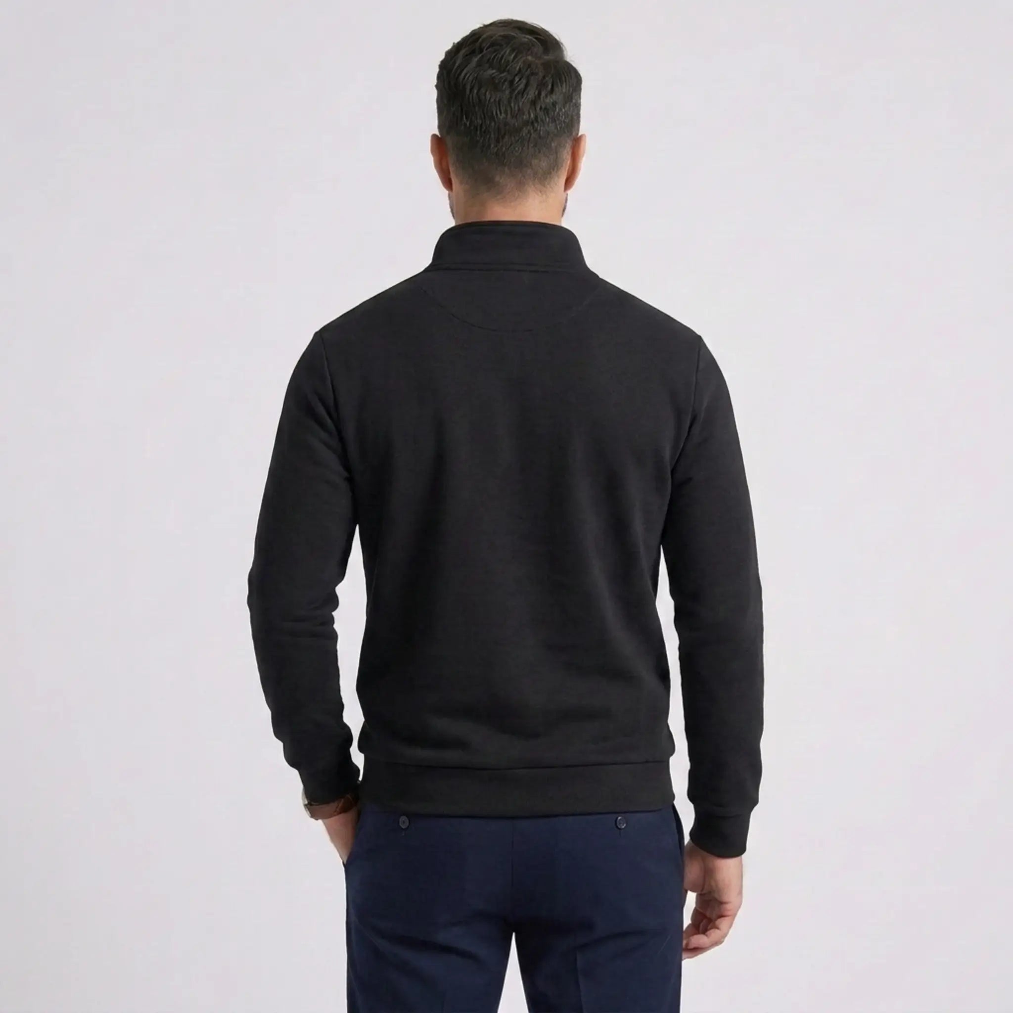 Man wearing MannerCo black quarter zip mock neck sweater slim fit, back view on plain background