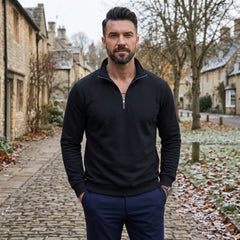 Man wearing MannerCo black quarter zip mock neck sweater in outdoor lifestyle setting