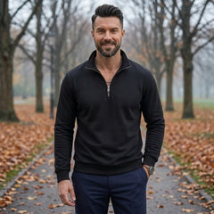 Man wearing MannerCo black quarter zip mock neck sweater in outdoor lifestyle setting