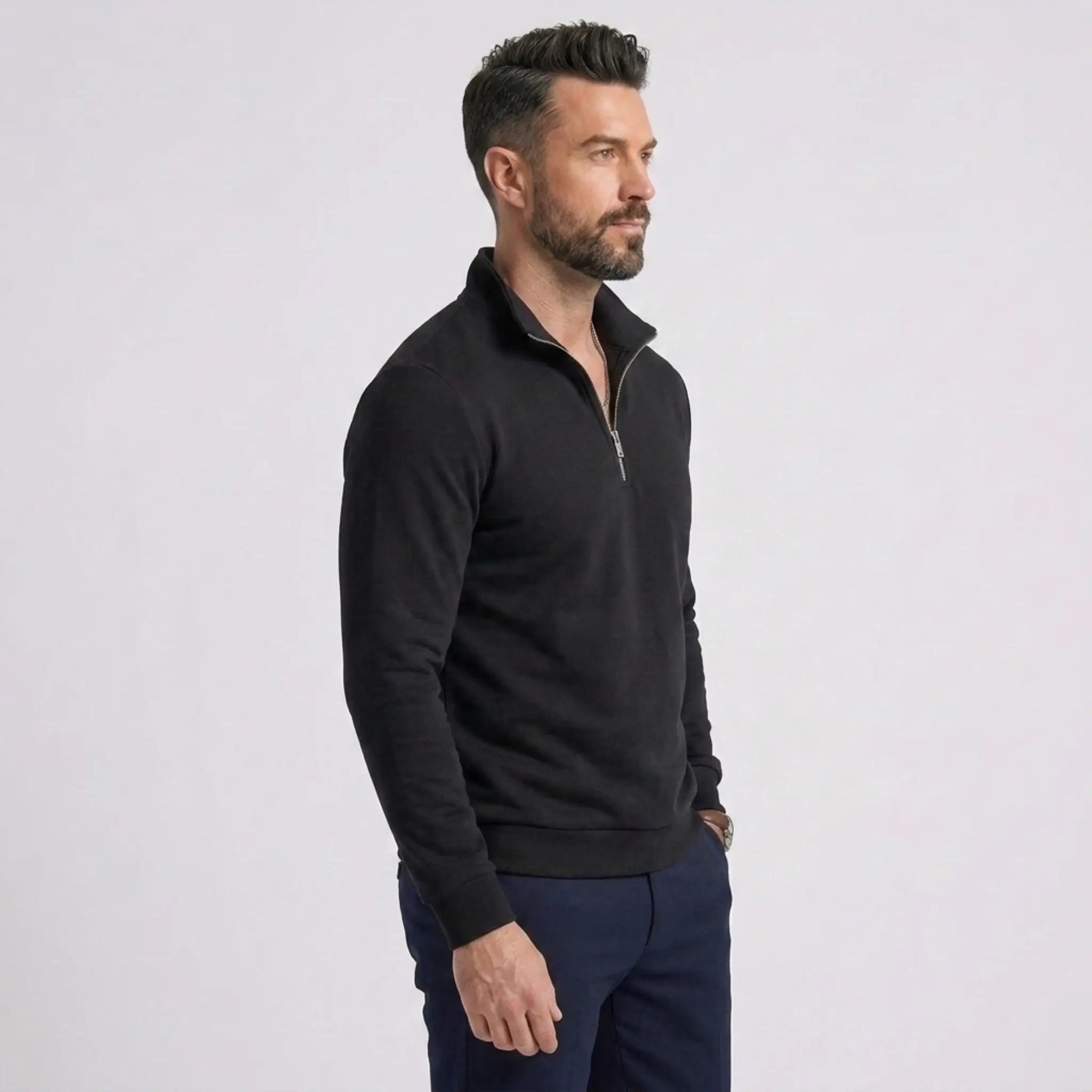 Man wearing MannerCo black quarter zip mock neck sweater slim fit, side view on plain background