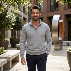 Man wearing MannerCo gray quarter zip mock neck sweater in outdoor lifestyle setting