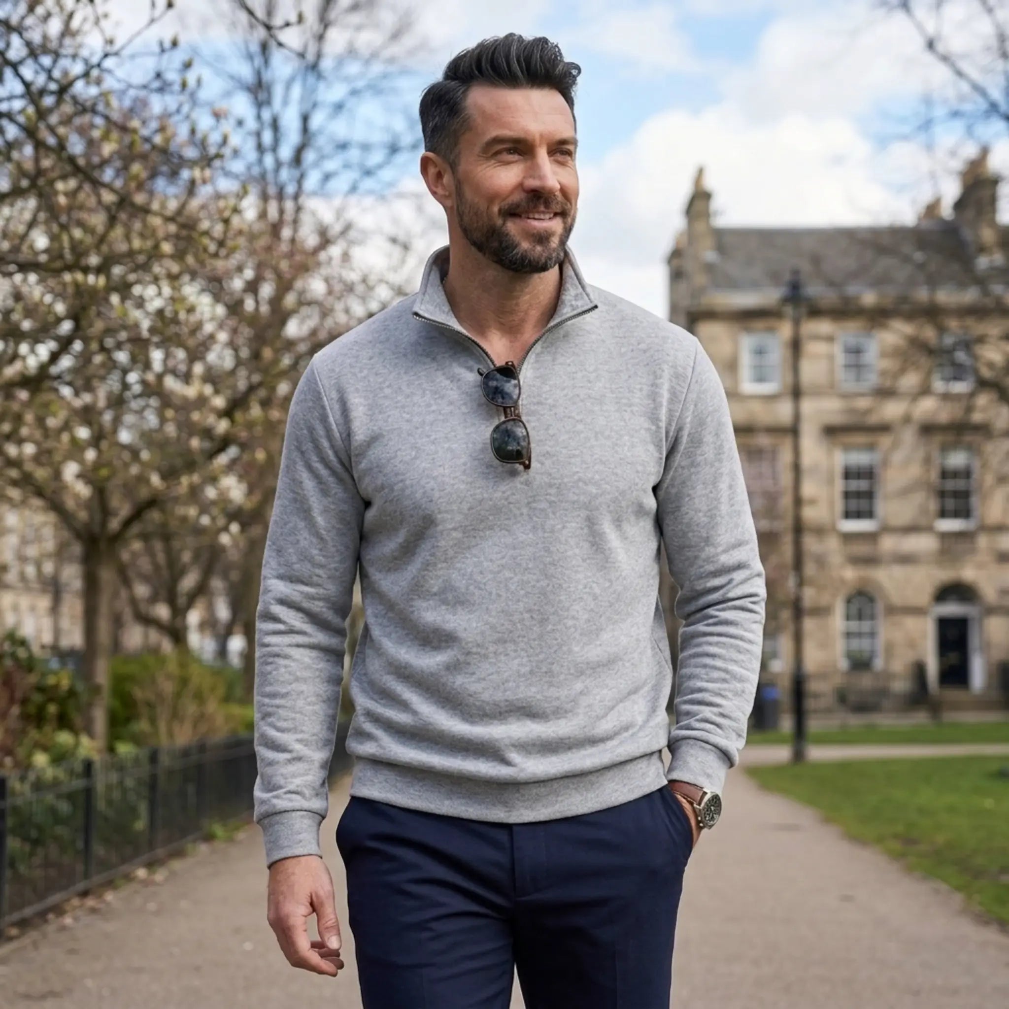 Man wearing MannerCo gray quarter zip mock neck sweater in outdoor lifestyle setting
