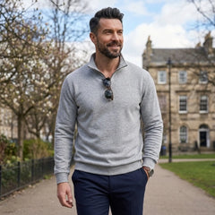 Man wearing MannerCo gray quarter zip mock neck sweater in outdoor lifestyle setting