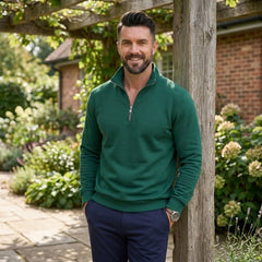 Man wearing MannerCo green quarter zip mock neck sweater in outdoor lifestyle setting