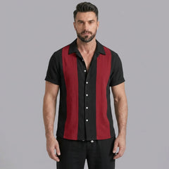Man wearing red patchwork bowling shirt and linen pants in outdoor lifestyle setting