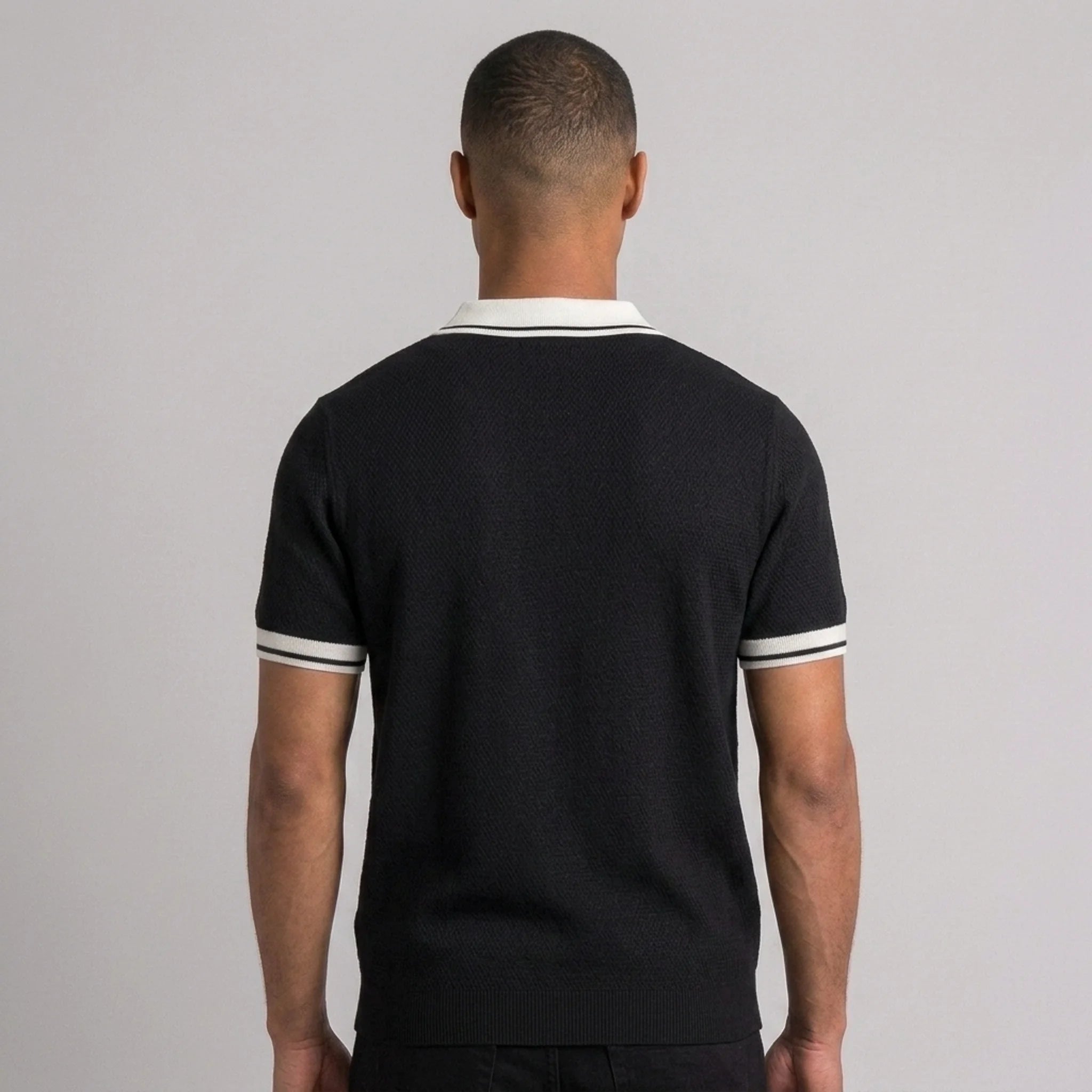 Man wearing royal blue color block knit polo shirt in outdoor lifestyle setting