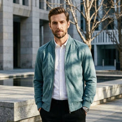 Man wearing MannerCo peacock blue suede thermal jacket over white shirt in urban outdoor setting