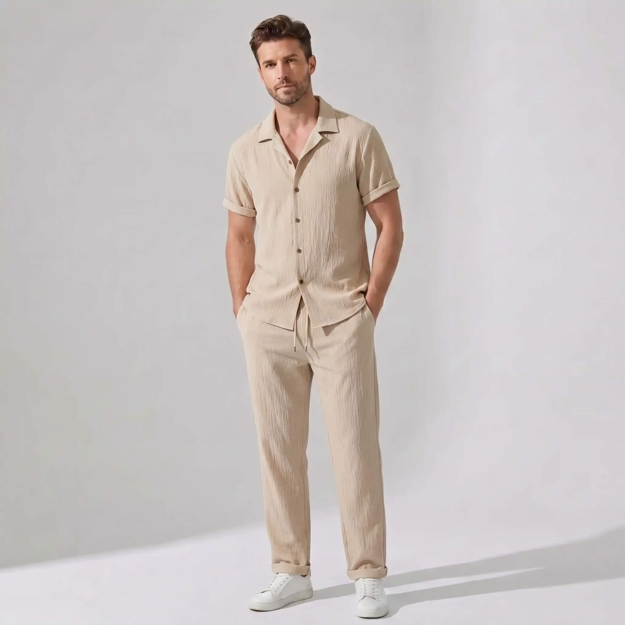 Man wearing a tan crinkled textured button up shirt and straight leg pants front view