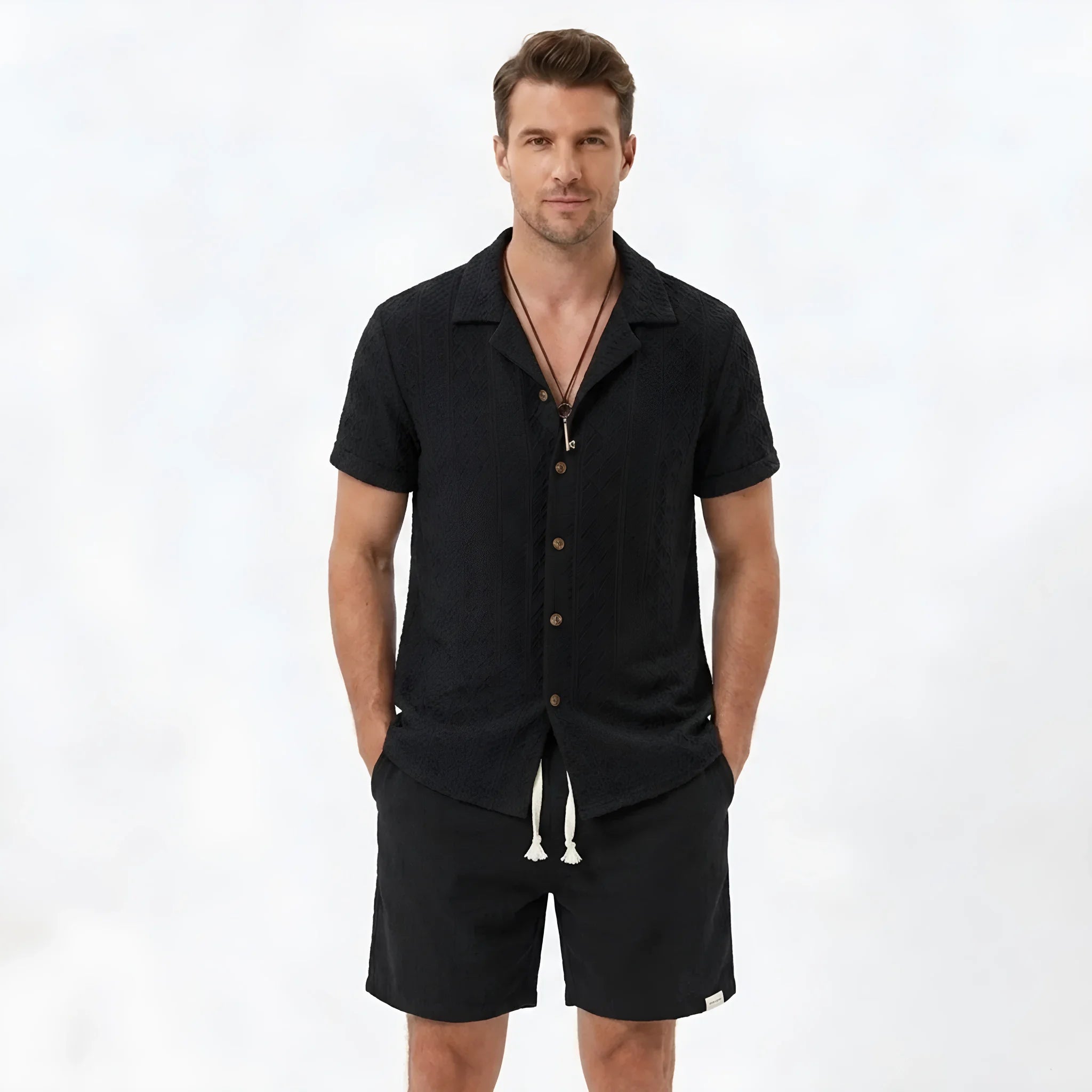 Back view of man wearing tan floral checkerboard jacquard Cuban shirt and linen drawstring shorts