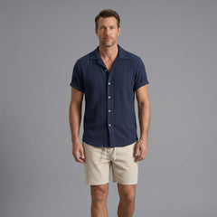 Man wearing a tan geometric jacquard button up shirt and crinkle textured shorts front view