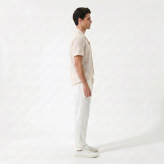 Man wearing tan geometric jacquard button up shirt and straight leg linen pants front view
