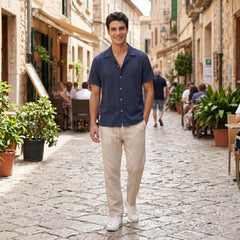 Man in tan geometric jacquard shirt and linen pants in outdoor lifestyle setting