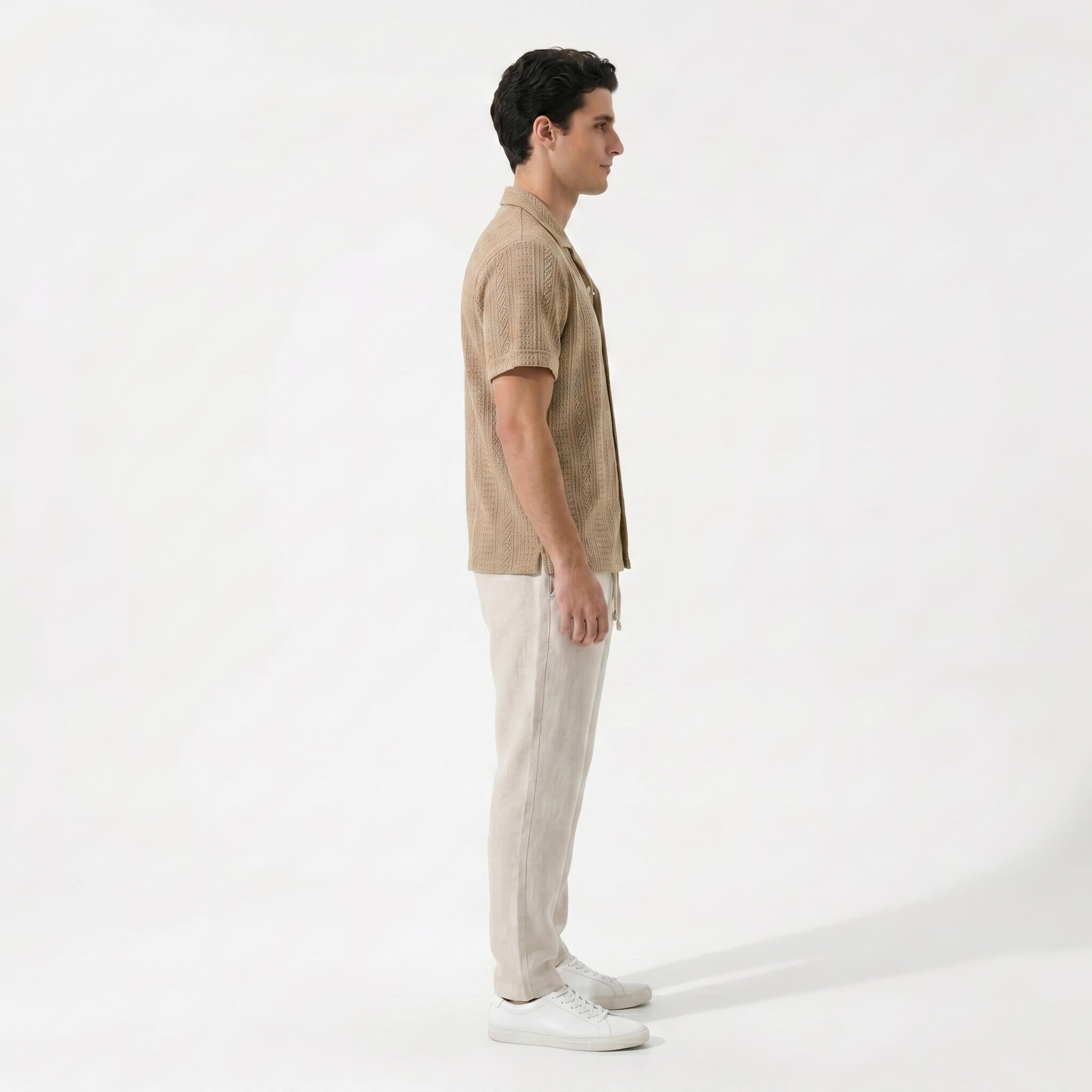 Back view of man in tan geometric jacquard shirt and linen pants in outdoor lifestyle scene