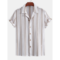 Full length front view of man wearing tan mesh Cuban collar shirt and straight leg beige pants