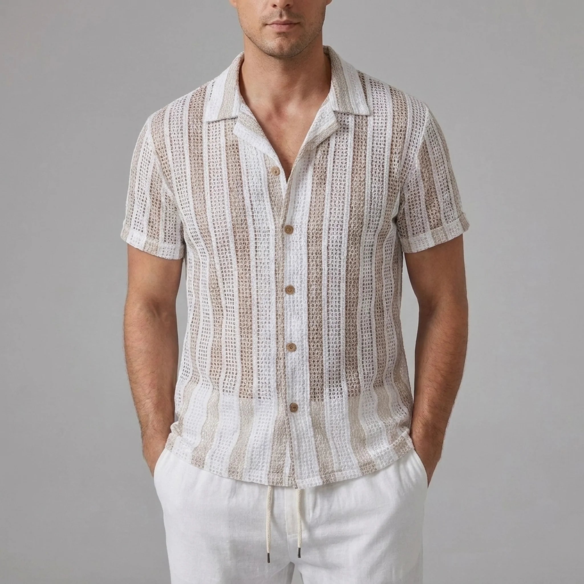 Back view of man in tan striped mesh Cuban shirt and beige linen pants against plain background