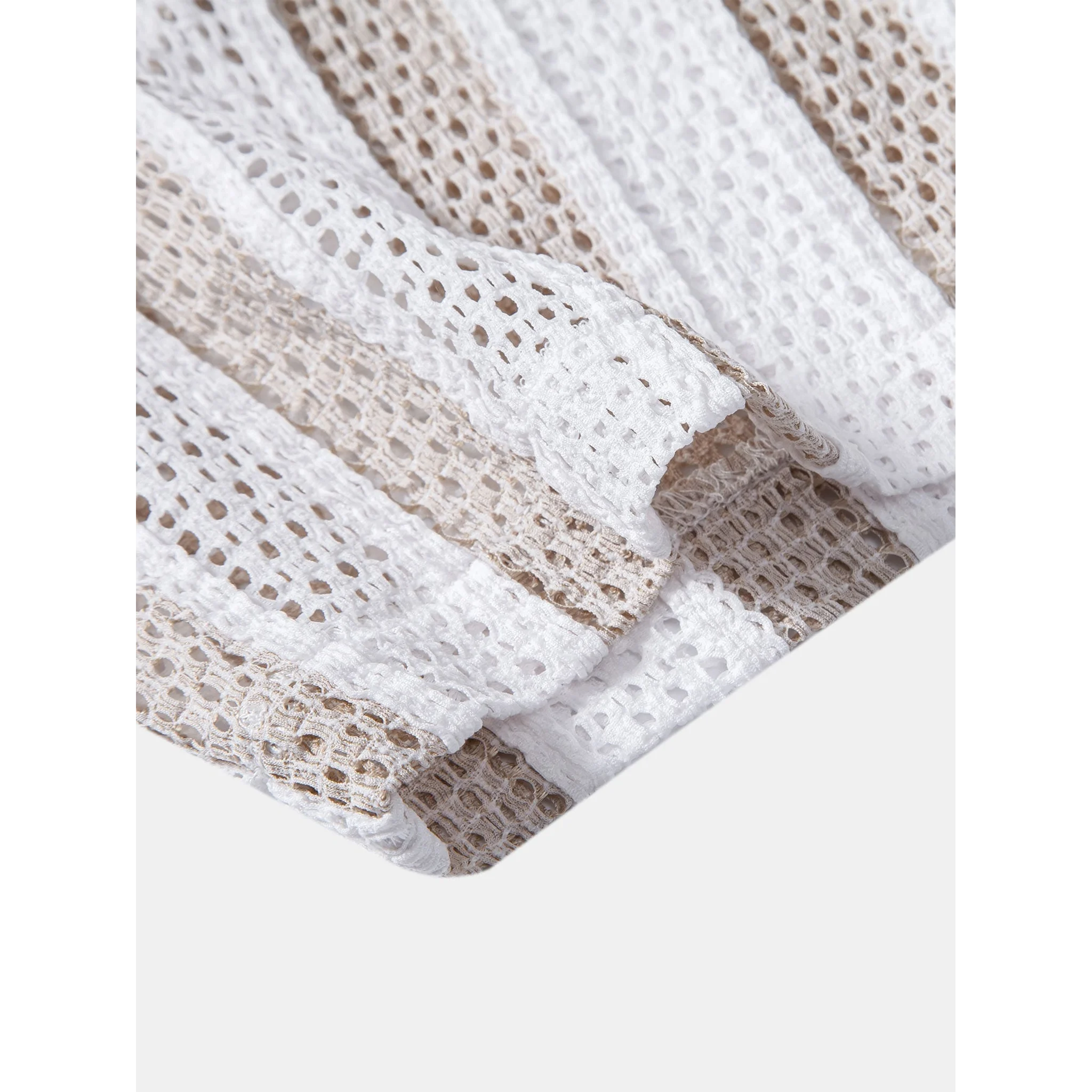Flat lay of tan striped mesh Cuban shirt and beige linen pants summer co-ord set on white background