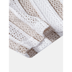 Flat lay of tan striped mesh Cuban shirt and beige linen pants summer co-ord set on white background