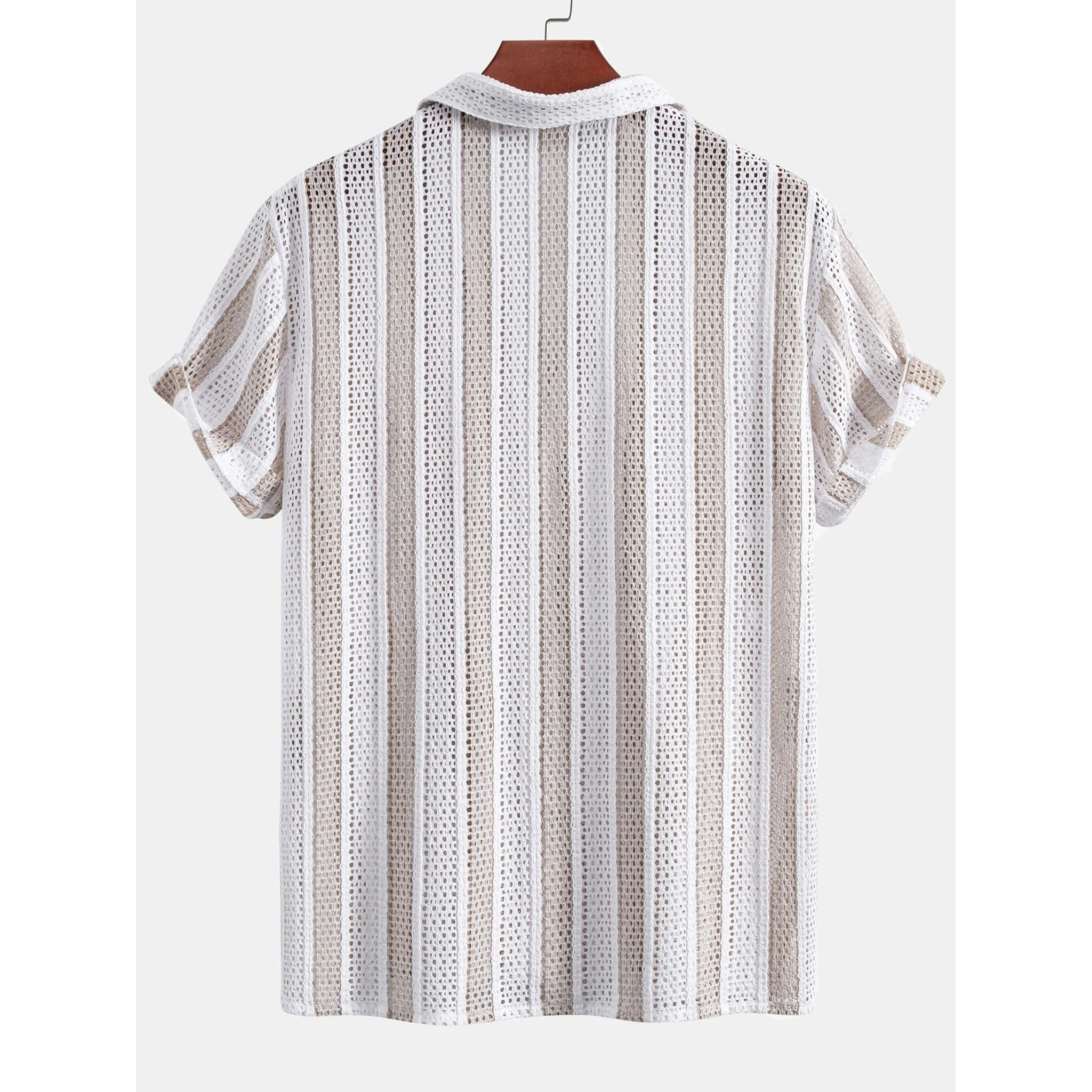 Man in tan open weave striped shirt and linen pants with hands at sides on plain background