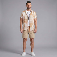 Three quarter view of man in tan tribal geometric patchwork shirt and swim shorts on plain background