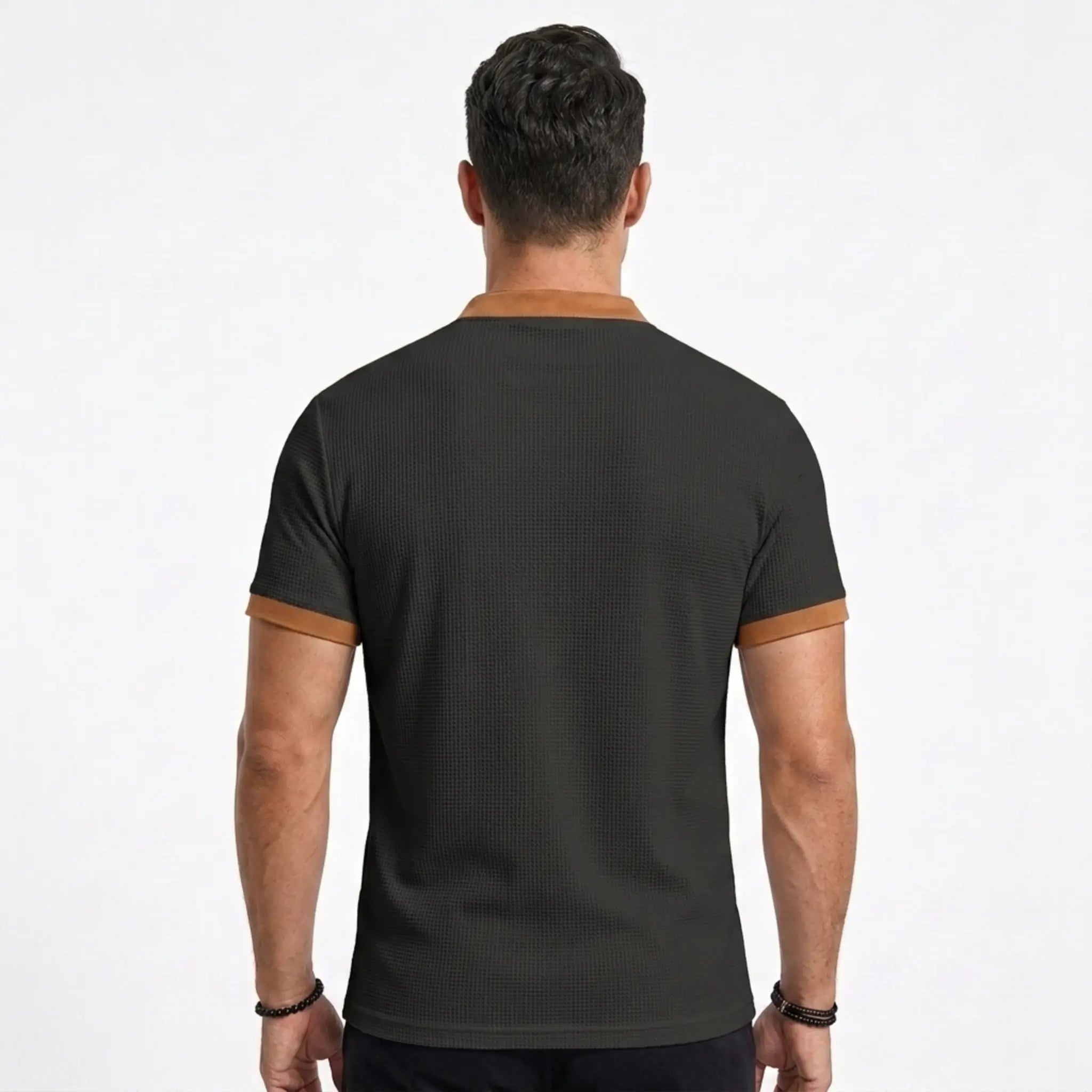 MannerCo black waffle knit polo back view with tan contrast collar and sleeve cuffs