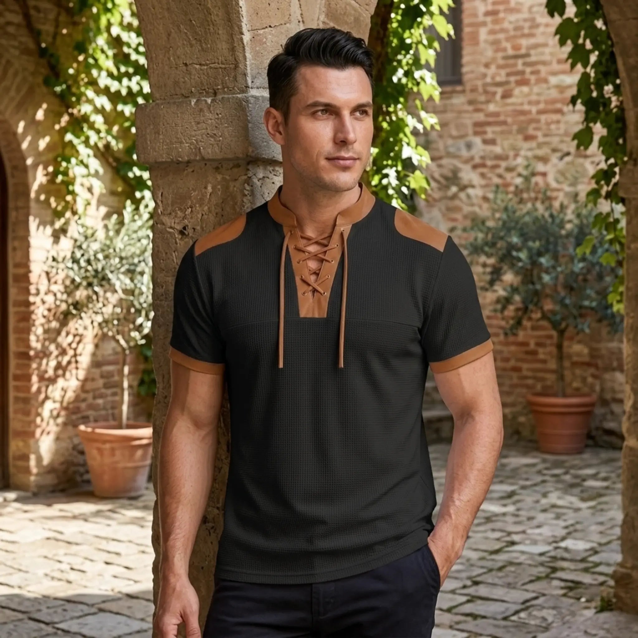 MannerCo black waffle knit color-block pullover with tan lace-up stand collar and shoulder panels, worn outdoors