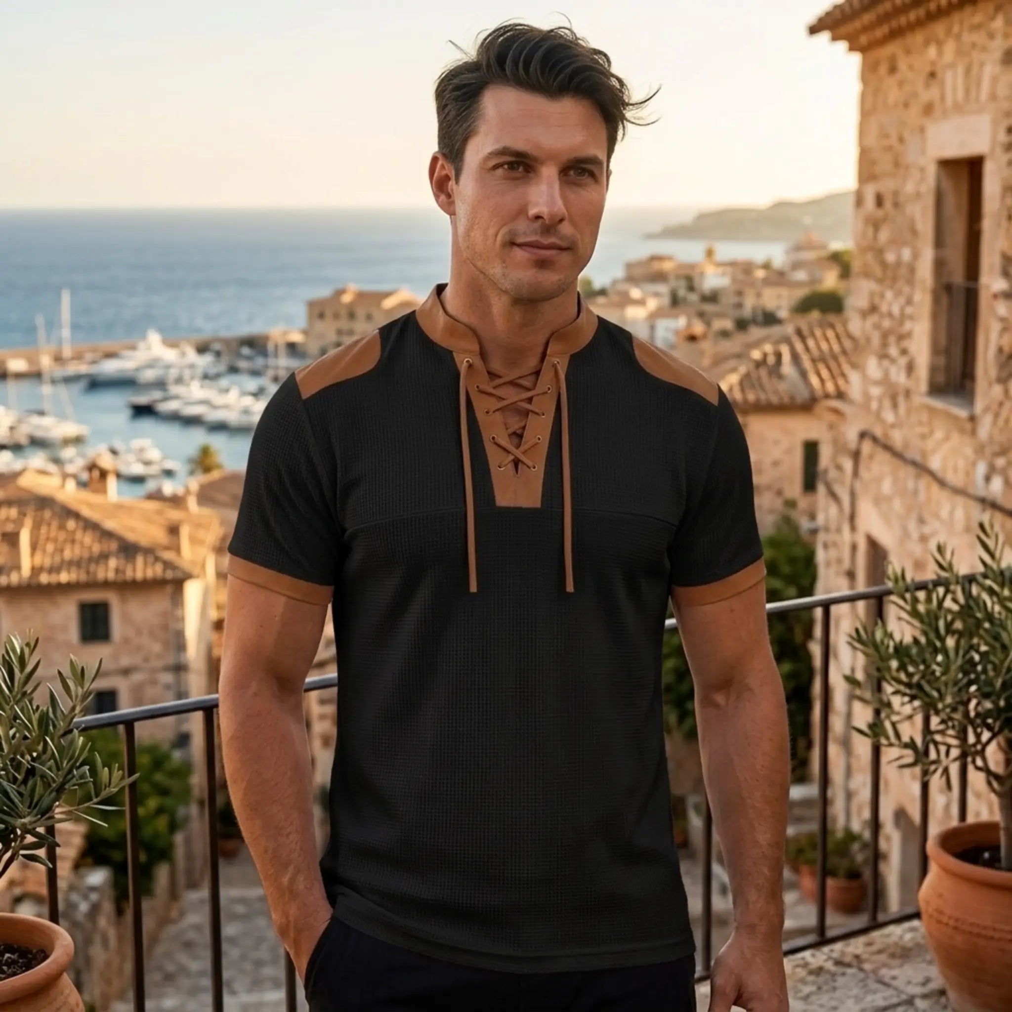 MannerCo black waffle knit pullover with tan lace-up collar and color-block shoulders, worn outdoors