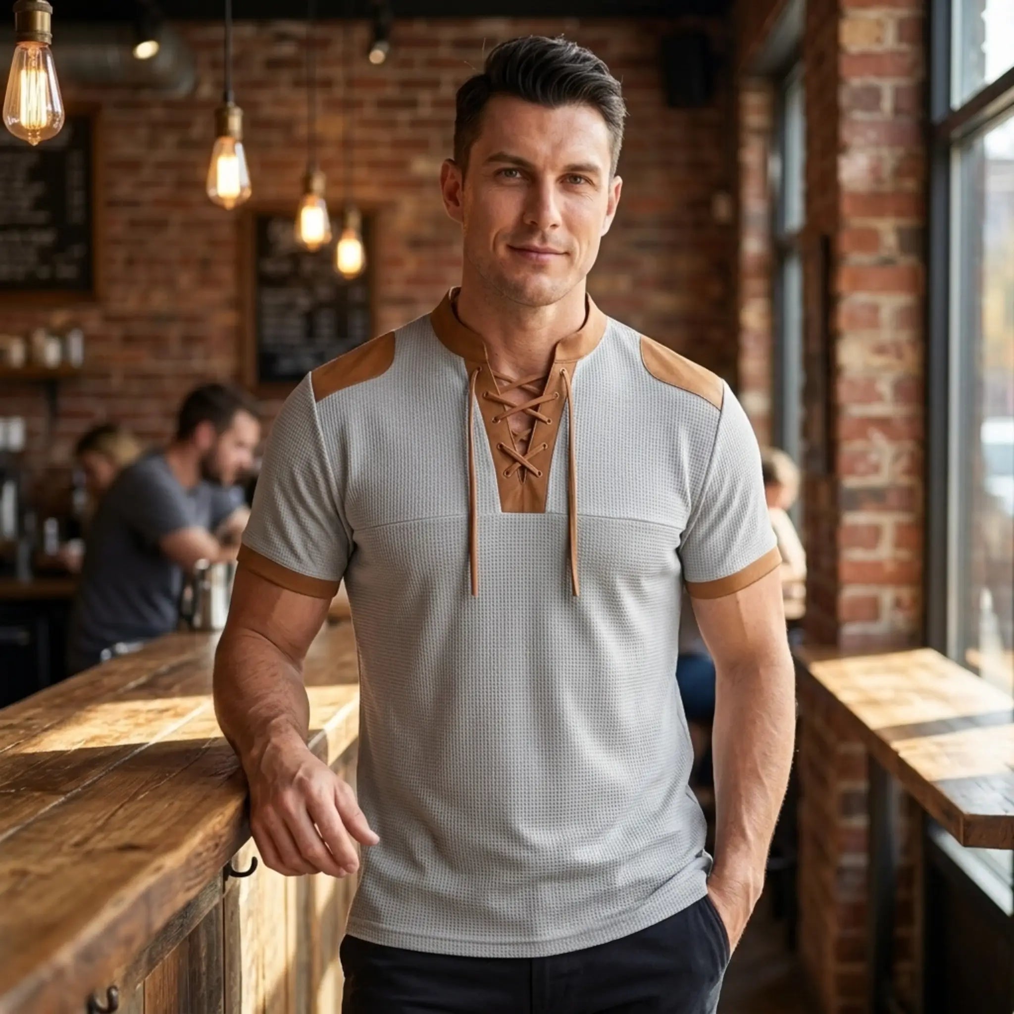 MannerCo light gray waffle knit lace-up pullover with tan color-block detail, worn by male model in cafe