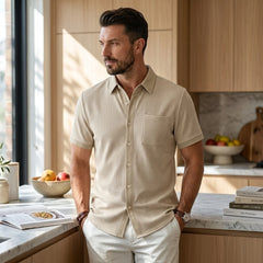 Man in khaki waffle knit short sleeve shirt with lapel collar standing in modern kitchen
