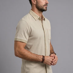 Man wearing khaki waffle knit short sleeve shirt with lapel collar and chest pocket, side view