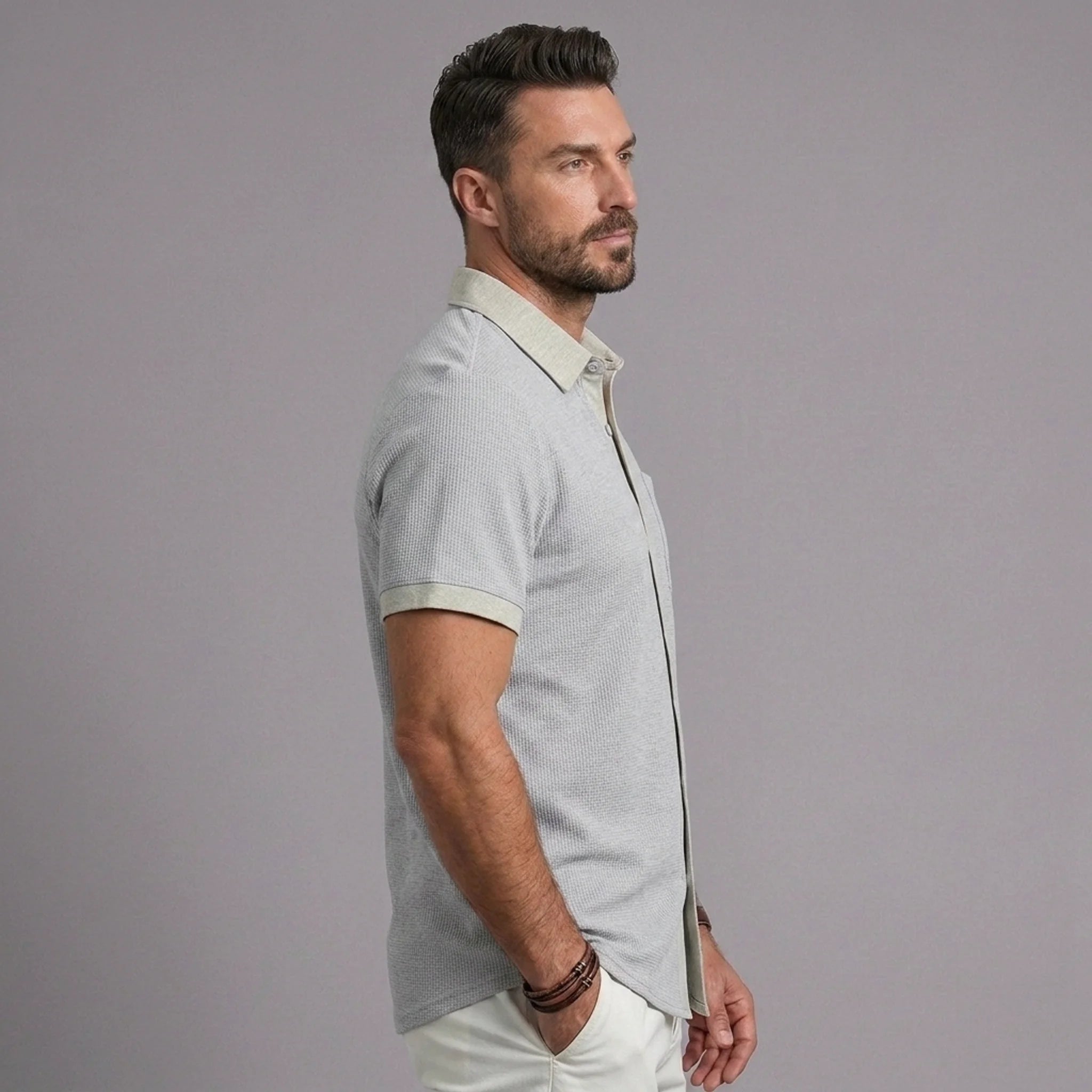 Man wearing light gray waffle knit short sleeve shirt with lapel collar, side view
