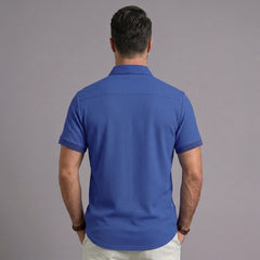 Back view of man wearing royal blue waffle knit short sleeve polo shirt with lapel collar