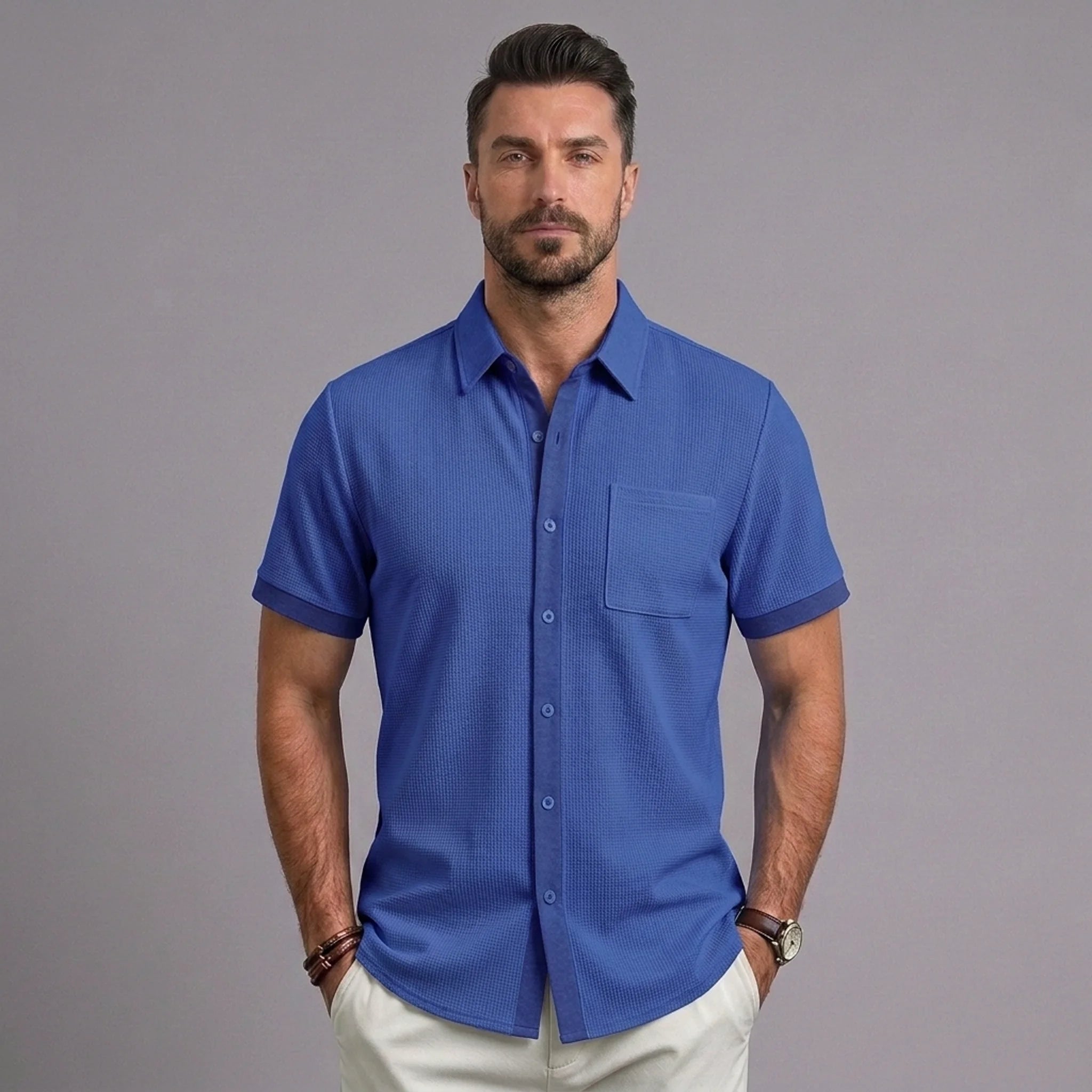 Man wearing royal blue waffle knit short sleeve casual shirt with chest pocket and white trousers