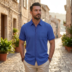Man wearing royal blue waffle knit short sleeve shirt on sunny cobblestone street
