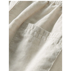 Man in white and beige geometry textured Cuban shirt and linen pants in outdoor lifestyle setting