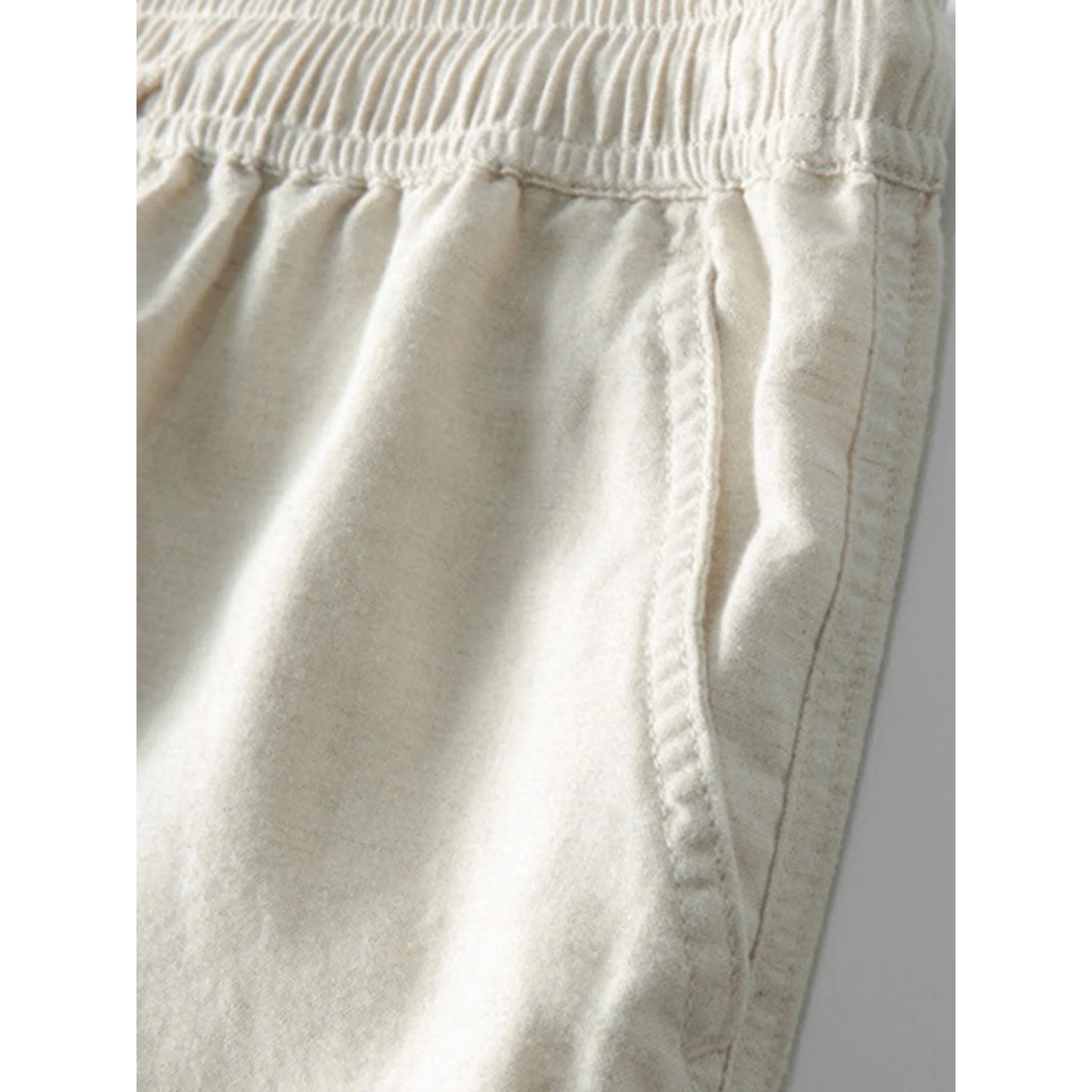 Three quarter view of man in white and beige geometry textured Cuban shirt and linen pants