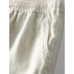 Three quarter view of man in white and beige geometry textured Cuban shirt and linen pants