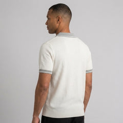 Back view of man wearing white color block knit polo shirt with lapel collar