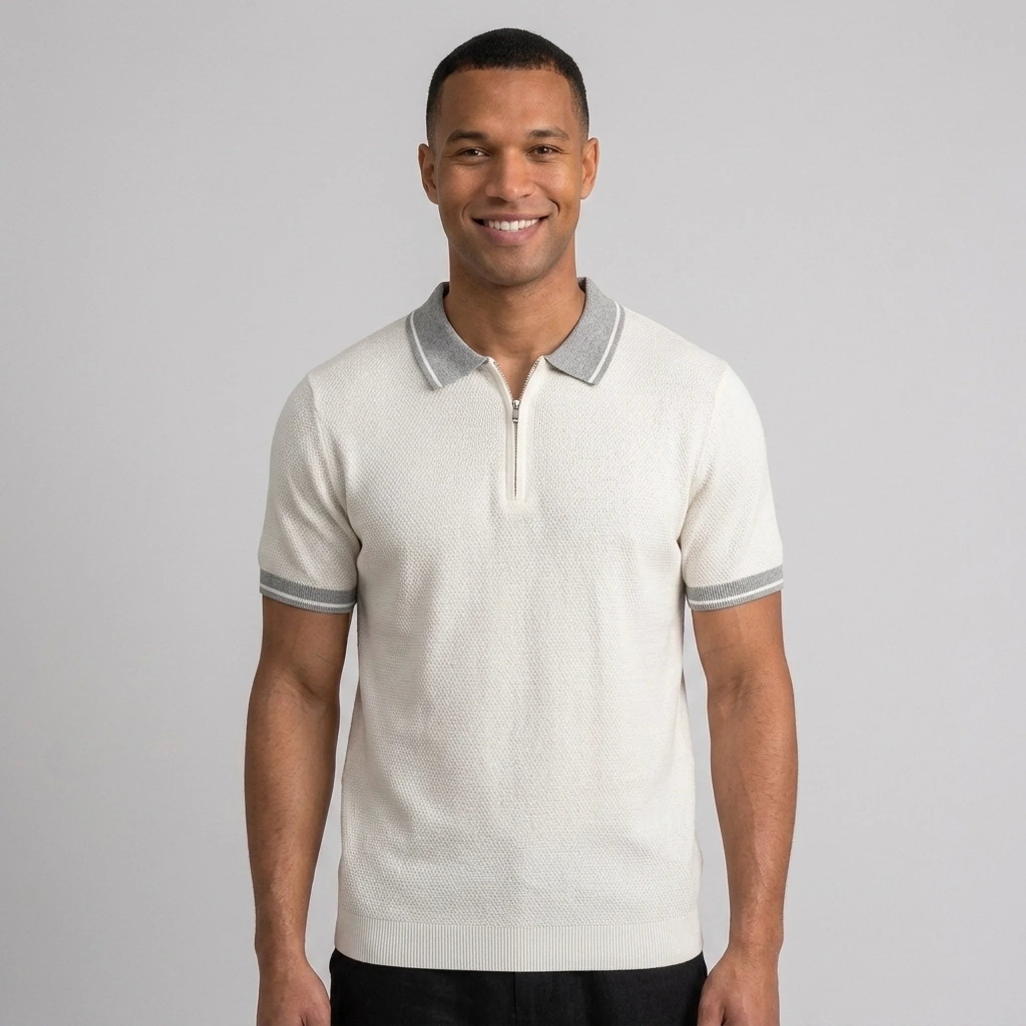 Man wearing a white color block knit polo shirt with lapel collar front view on plain background