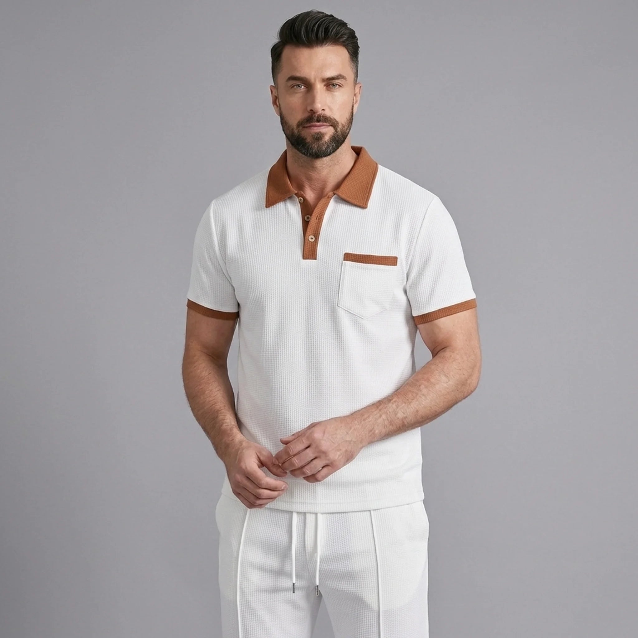 Man wearing a white color block waffle polo and straight leg pants front view on plain background