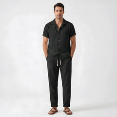 Man wearing white floral checkerboard jacquard Cuban shirt and linen pants in outdoor lifestyle setting