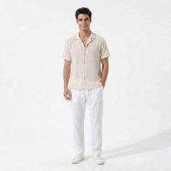 Back view of man wearing white geometric jacquard button up shirt and straight leg linen pants