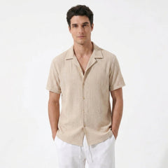 Man wearing white geometric jacquard button up shirt and straight leg linen pants front view