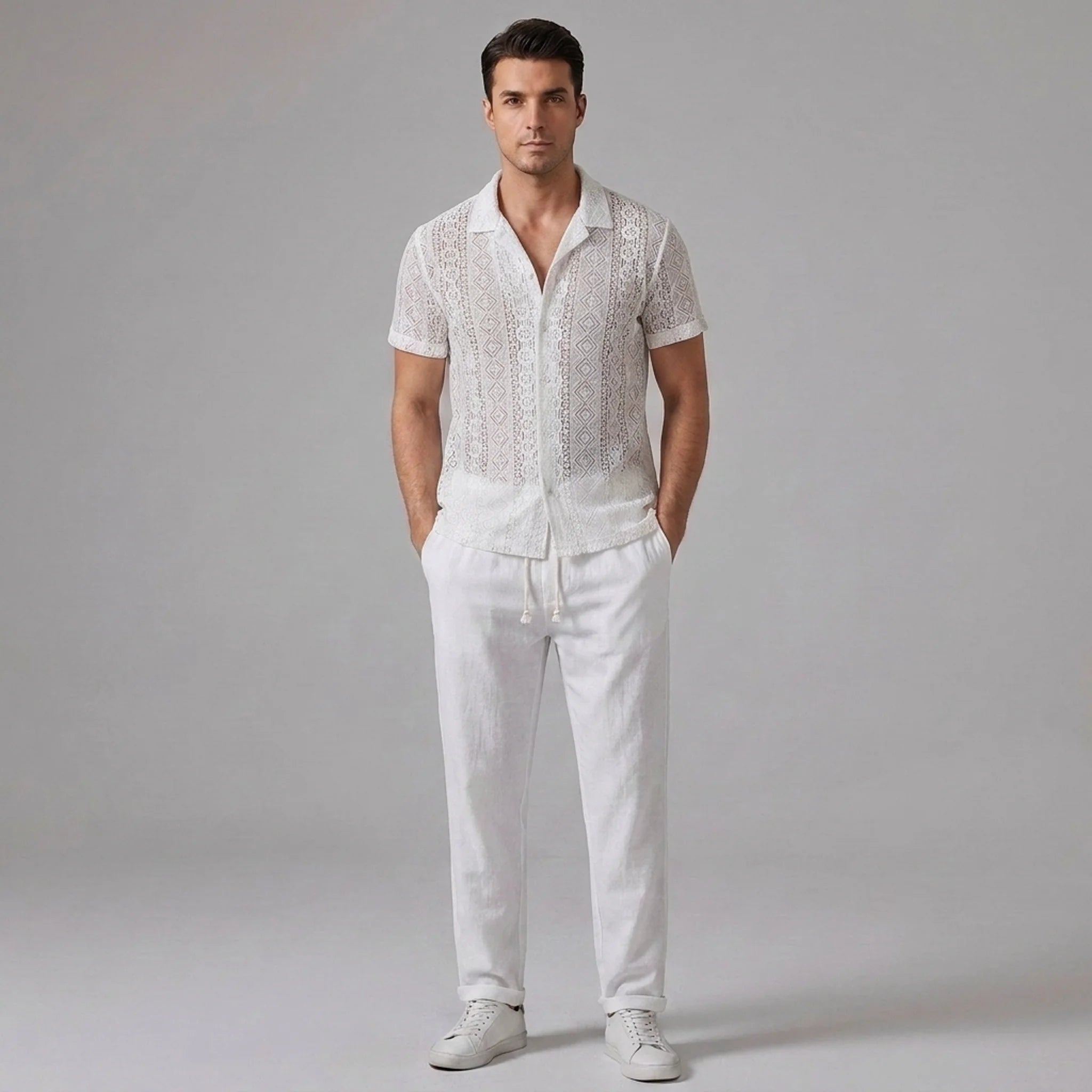 Man wearing a white geometry textured Cuban shirt and straight leg linen pants front view on plain background